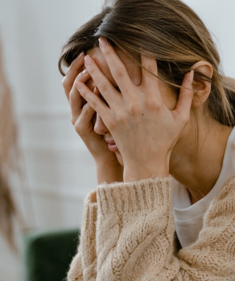 Dekorativ bild på en kvinna som sitter med huvudet i händerna