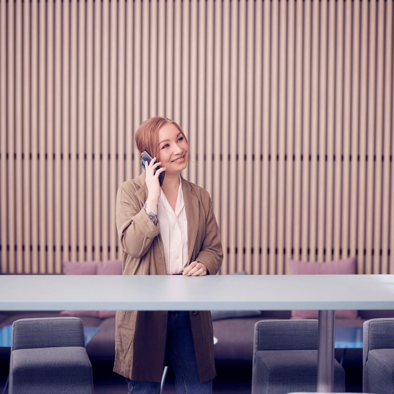 Dekorativt foto av en person som pratar i telefon och ler.