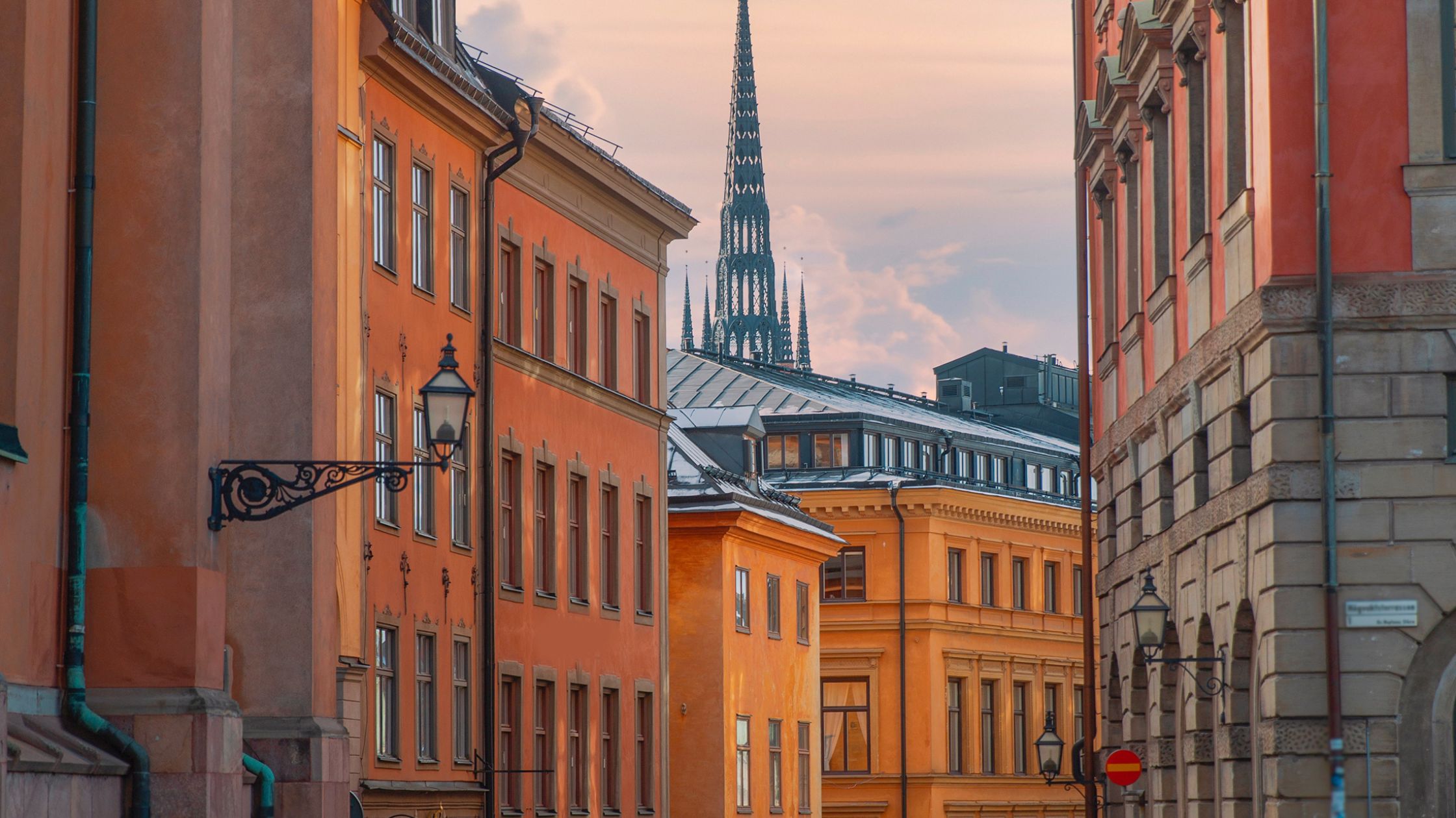 en klassisk gata i stockholms gamla stad med hur var sida i röda till gula nyanser