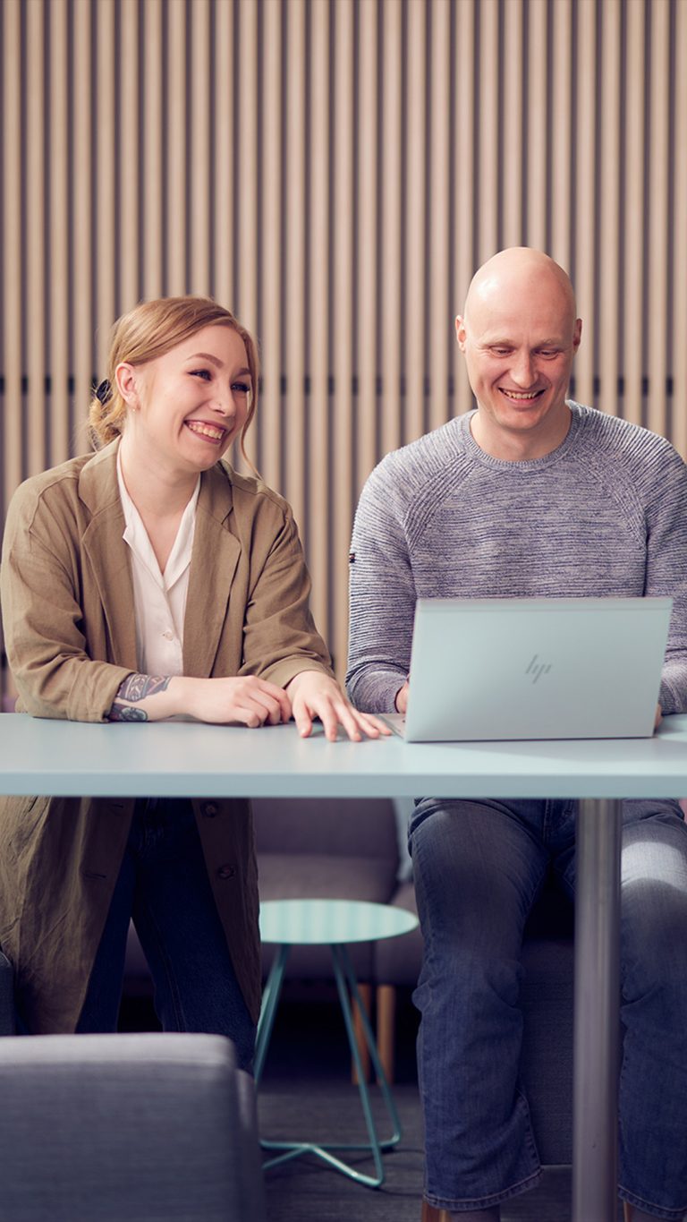 Dekorativt foto av två personer som skickar en öppen jobbansökan med en dator.