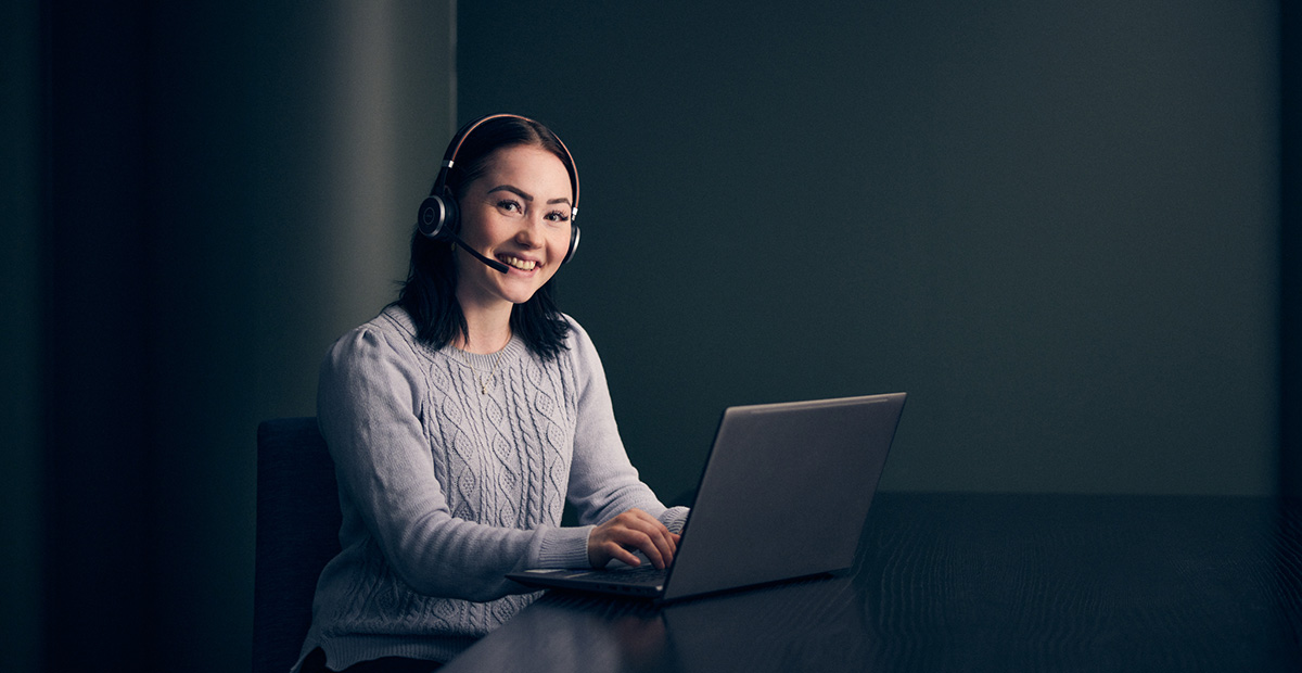 Decorative image of a customer service person talking to a customer with headphones.