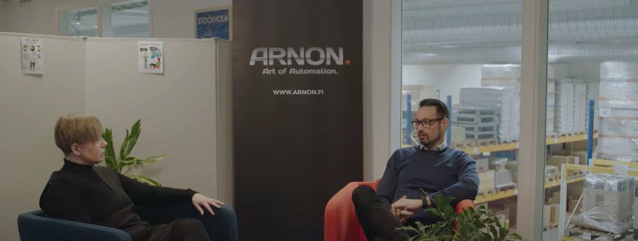 Två Arnon-anställda sitter och pratar på sitt kontor