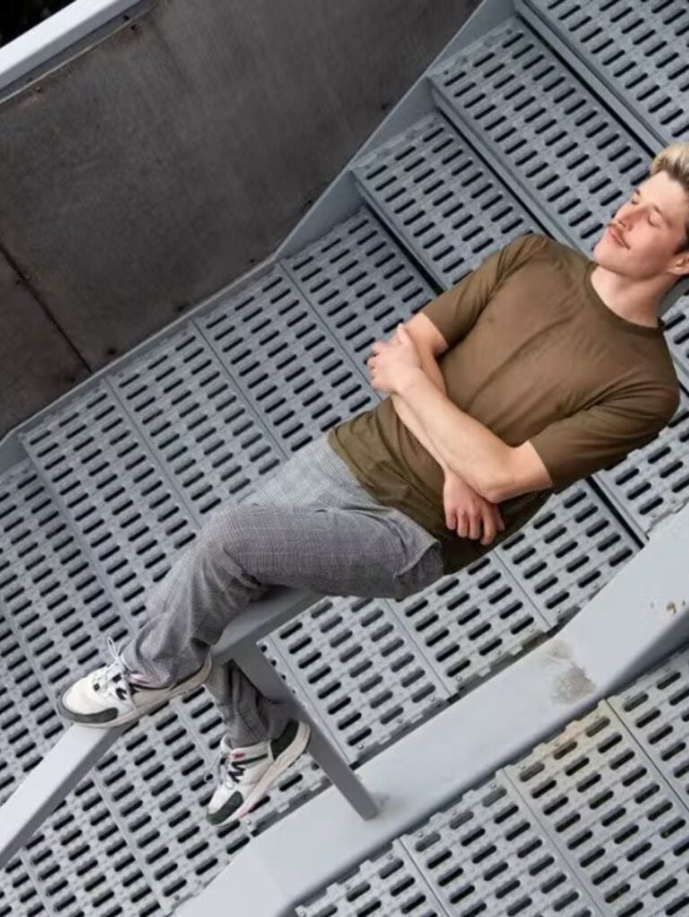 Dekorativ bild på en ung man som ligger över ett trappräcke
