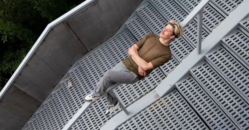 Dekorativ bild på en ung man som ligger över ett trappräcke