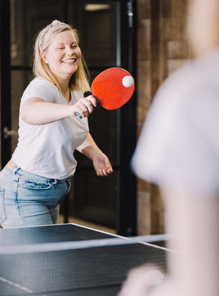 Dekorativ bild av kollegor som spelar bordstennis på kontoret