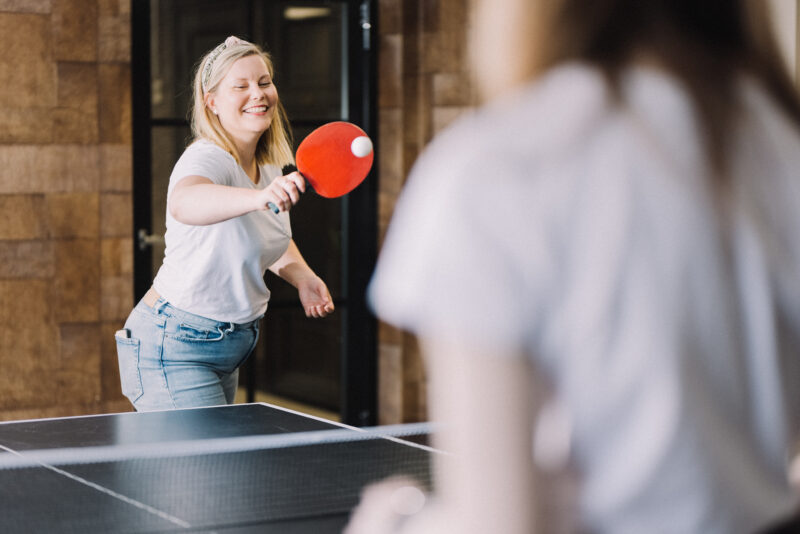 Dekorativ bild av kollegor som spelar bordstennis på kontoret