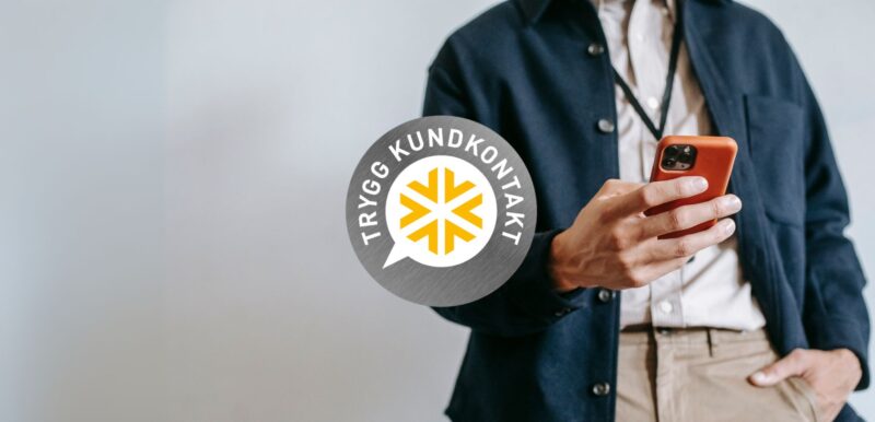 Dekorativ bild som föreställer en person med en mobiltelefon i handen och framför synd Kontaktas "trygg kundkontakt" emblem.