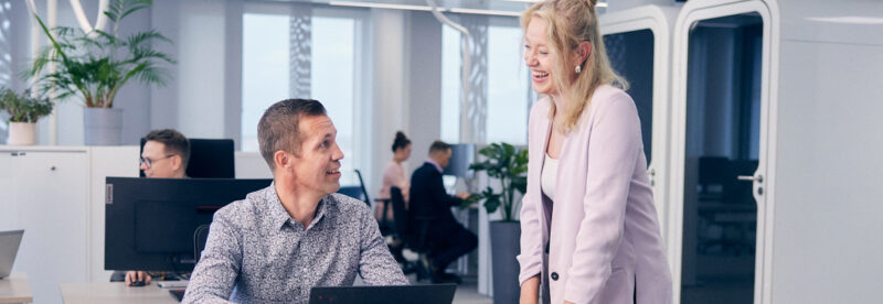 Dekorativ bild som föreställer två kollegor i kontorsmiljö