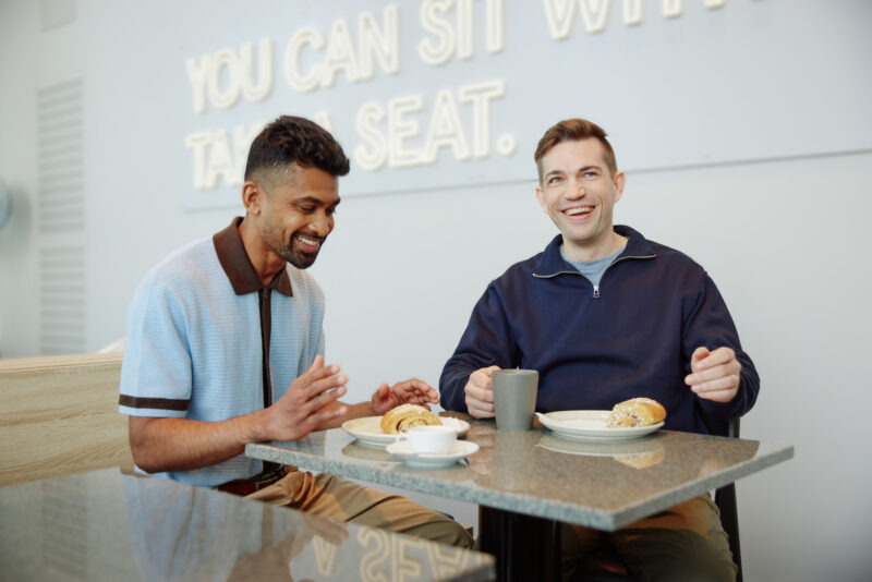 Dekorativ bild på två kollegor vid ett café bord