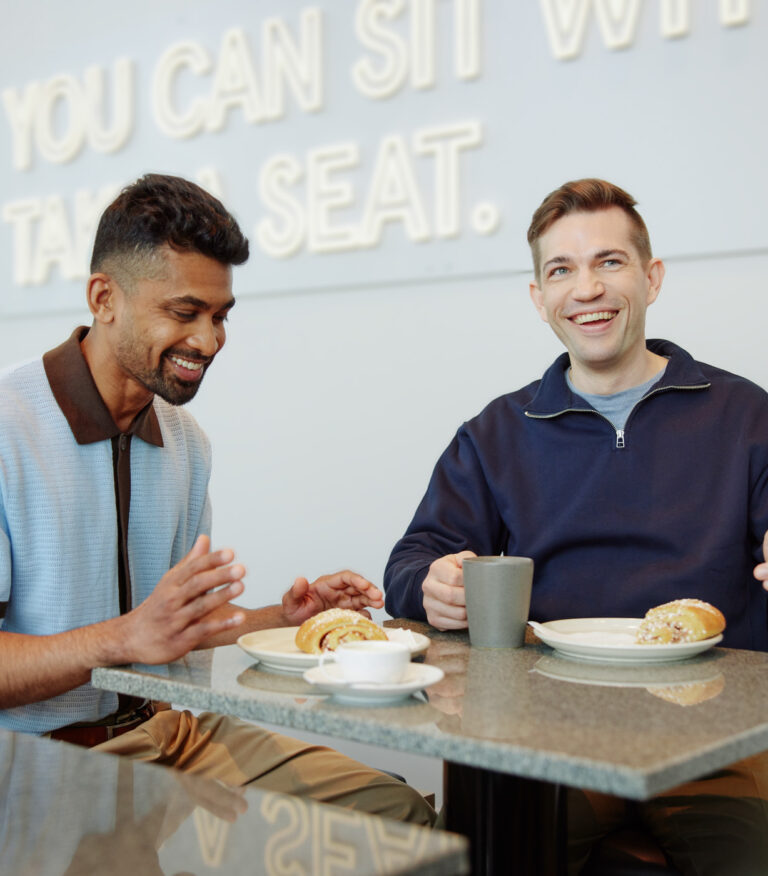 Dekorativ bild på två kollegor vid ett café bord