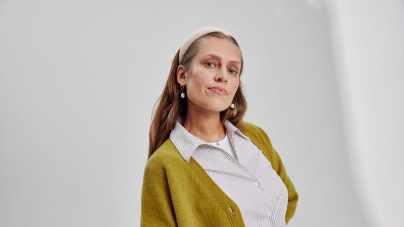 Dekorativ bild som föreställer. en kvinna i skjorta och gul tröja