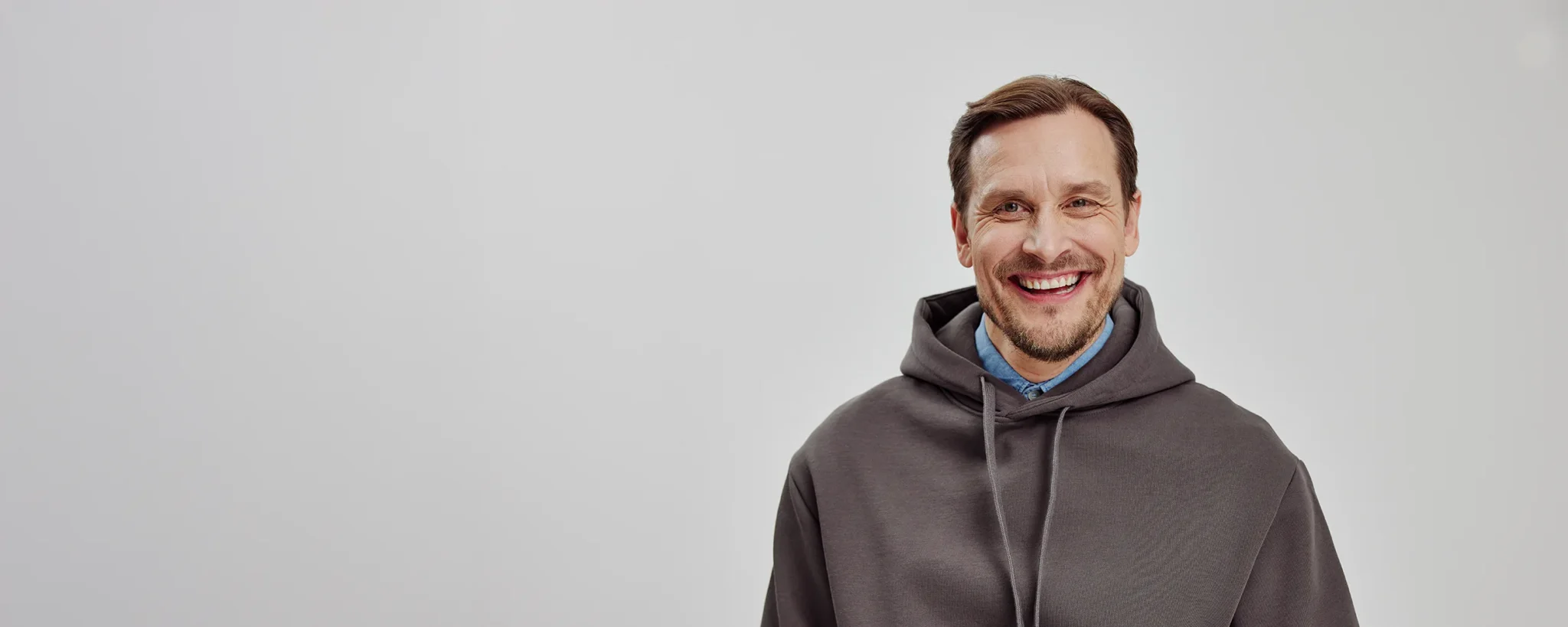 Dekorativ bild som föreställer en man i grå hoodie