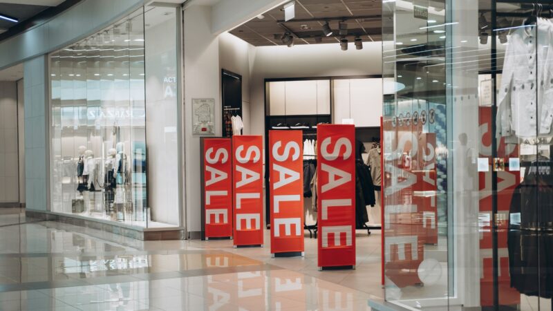 Dekorativ bild som föreställer skyltar me ordet "sale" i en butik