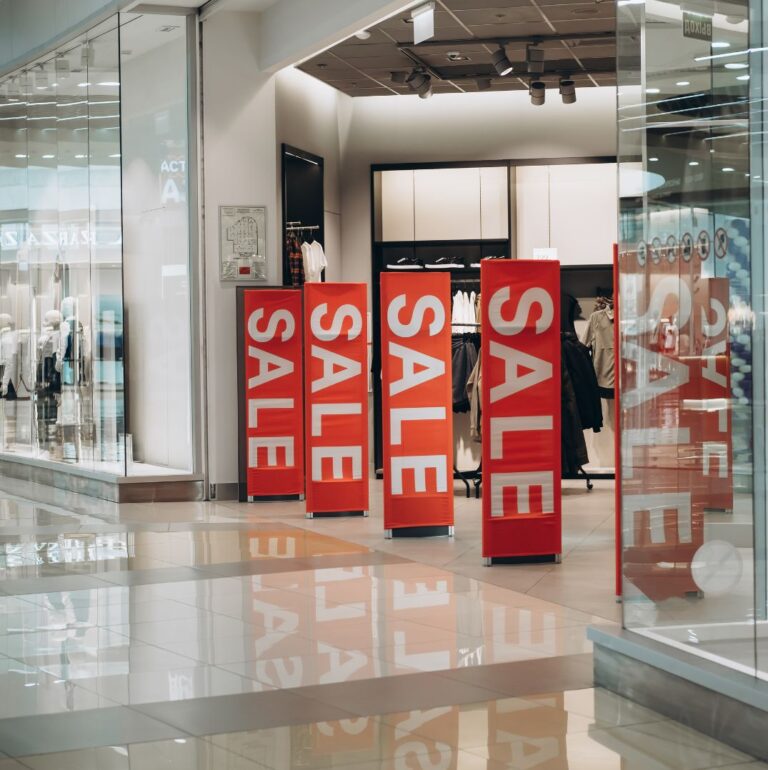 Dekorativ bild som föreställer skyltar me ordet "sale" i en butik